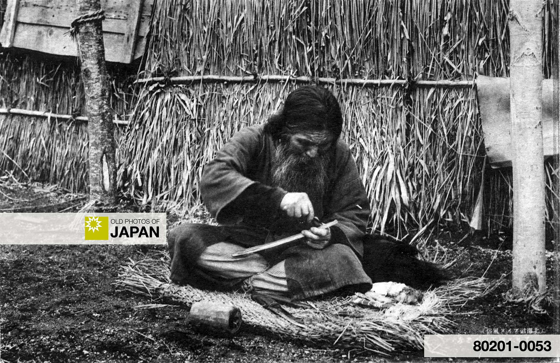 80201-0053 -  An Ainu man carving wood, 1920s